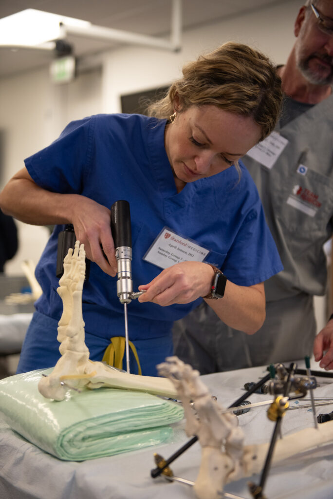 April Jensen, a practicing general surgeon in Albany, Oregon, practices a new skill during the International Humanitarian Surgical Skills Course led by Sherry Wren in January 2024.