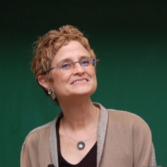 Michele Barry smiles against a green background